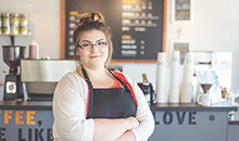 Restaurant owner smiling with her arms crossed