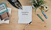 A desk with a paper that states Marketing Strategy