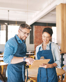 A man and a woman looking at a clipboard