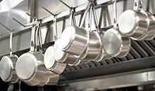 Silver pots and pans hanging on hooks