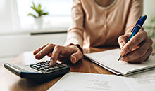 Lady using a calculator and a pen