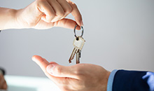 Someone handing keys to another person.