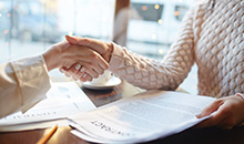 Two people shaking hands after making a deal.