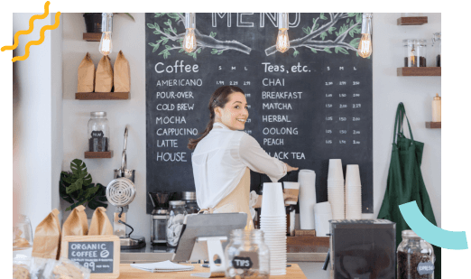 A barista looking back to greet a guest